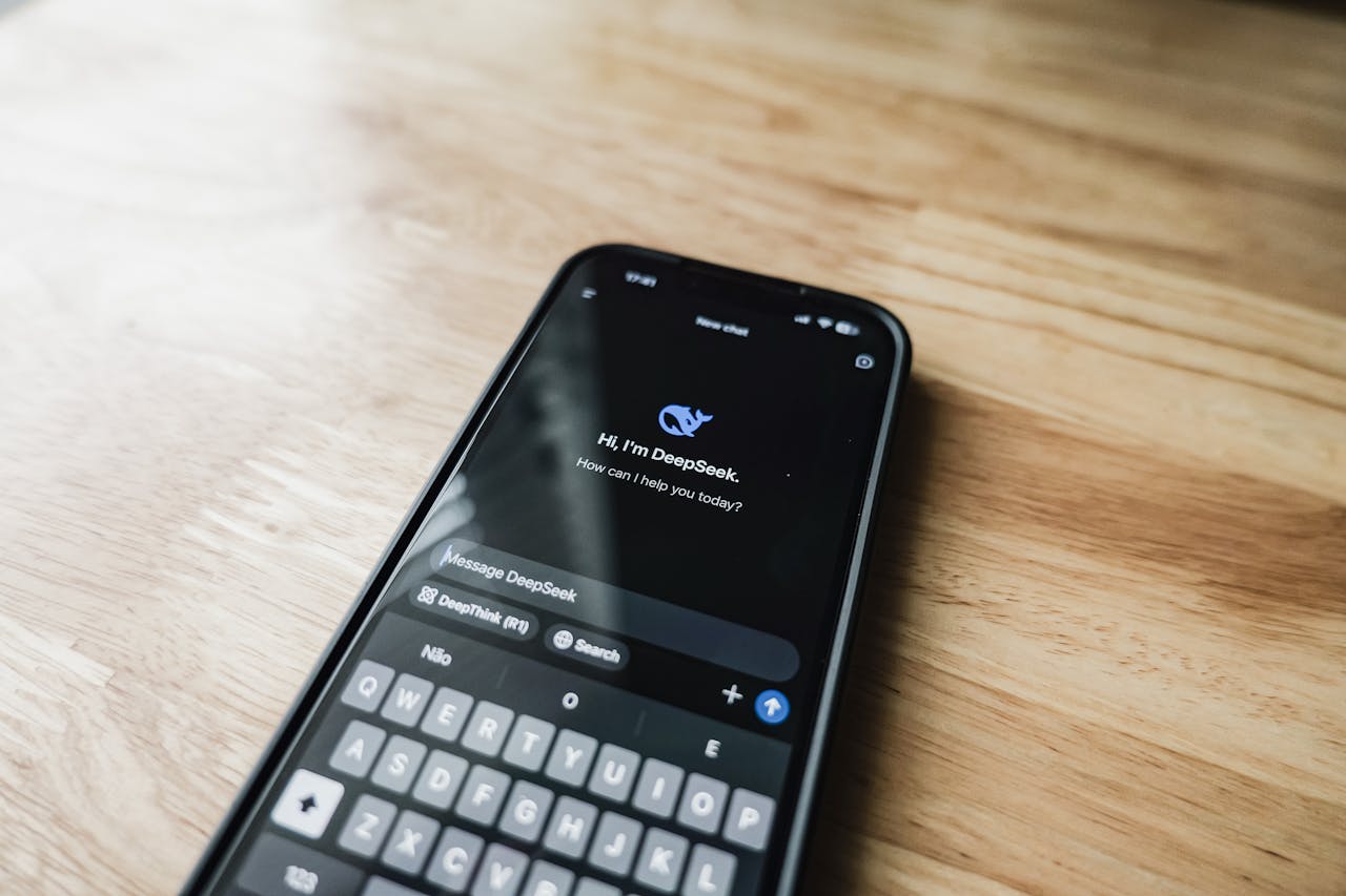 why-choose-us A smartphone displaying an AI chat interface, DeepSeek, on a wooden table.